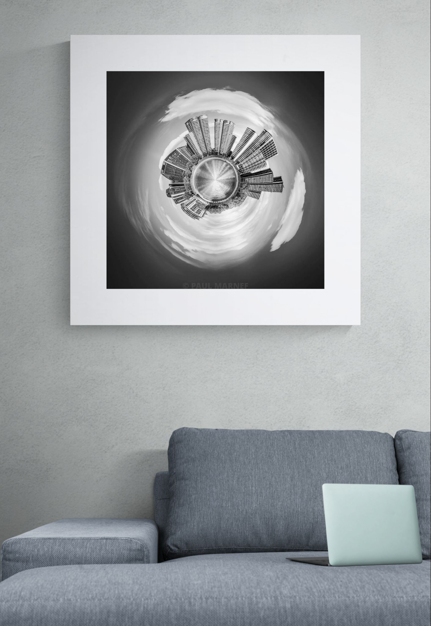 Simulation of an interior display: ‘L’Œil de la City’, black-and-white mini-planet-style buildings above a grey sofa