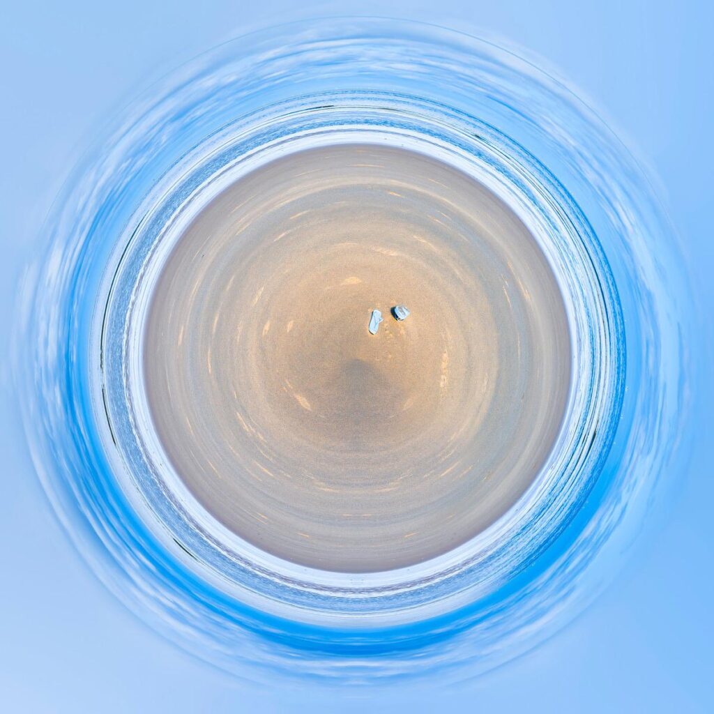 Céleste cercle de ciel bleu entourant une plage vue en rotation, formant des spirales où les vagues viennent lécher le sable.