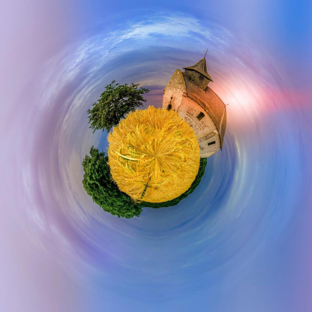 A spherical view showing a church and trees with a faux gold finish.