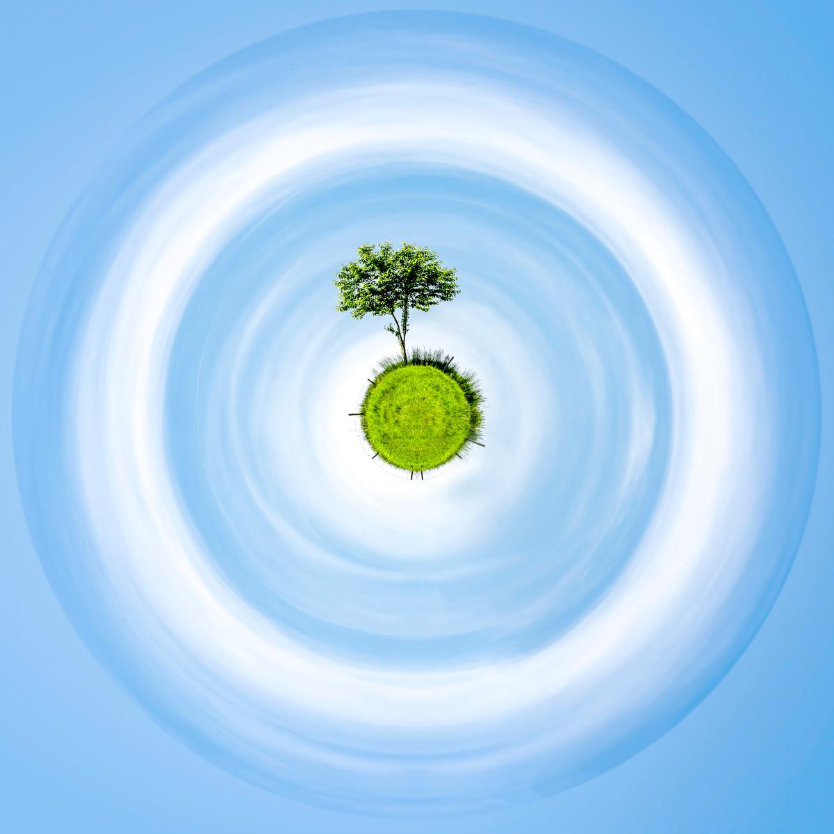 Arbre isolé sur un tertre vert, entouré de cieux bleus en spirales lumineuses et effectuant une rotation vertigineuse.