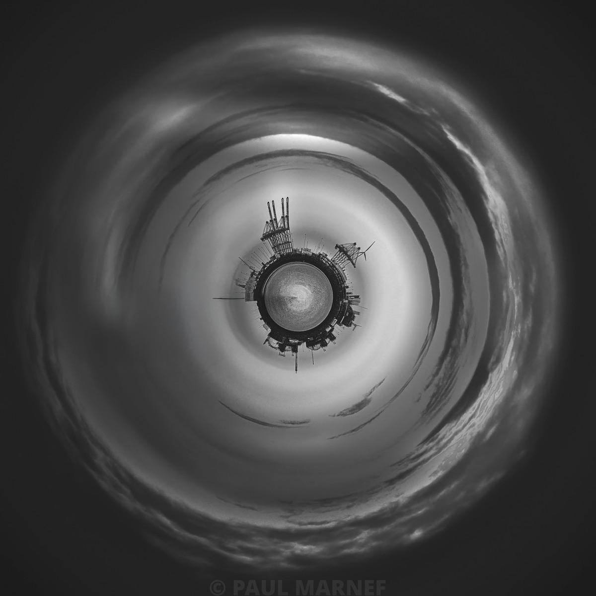 Tourbillon de nuages gris entourant une plateforme industrielle centrale par une vue trapézienne.