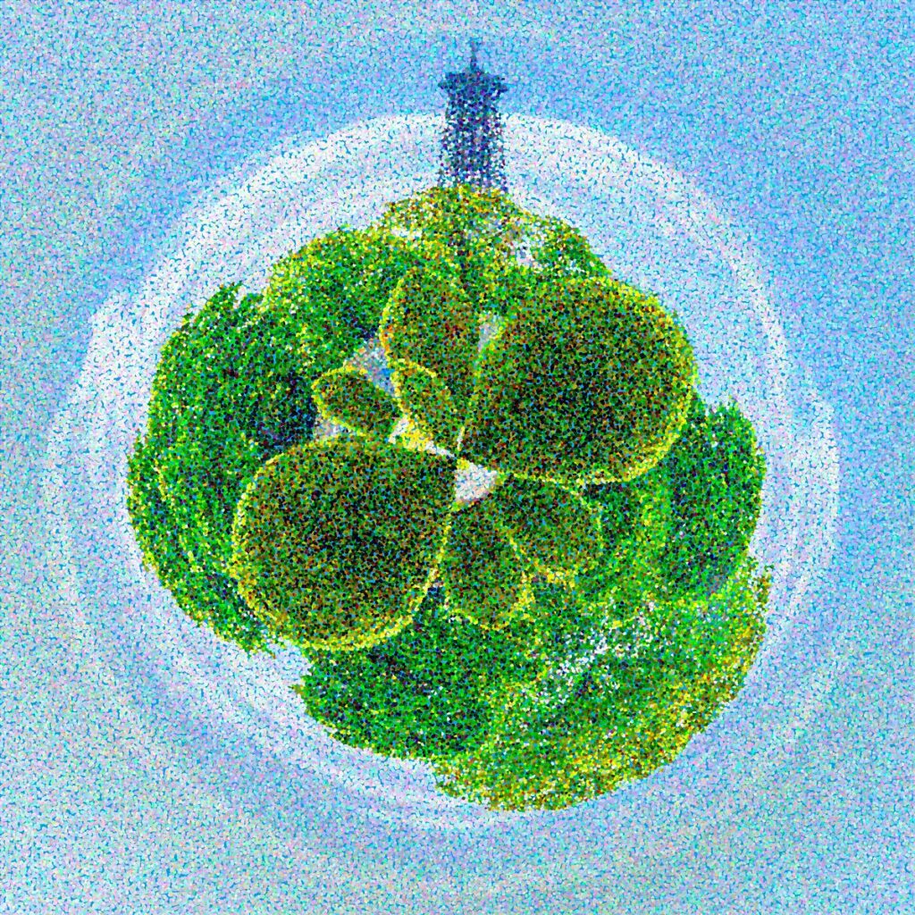 An aerial view of geometric topiary beds forming a plant pattern, with the dark silhouette of the Eiffel Tower emerging from the central circular structure.