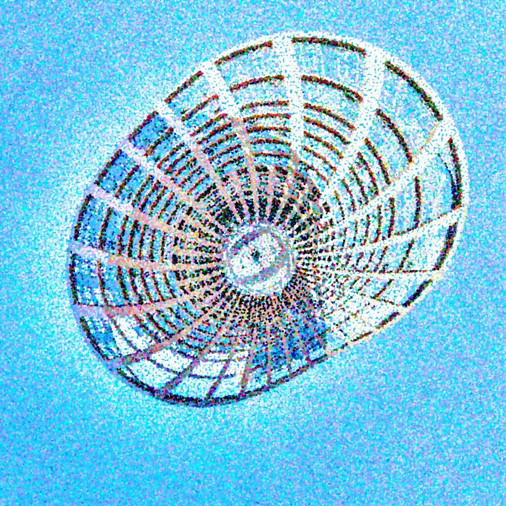 Cercle de fil de fer noir formant une grille géométrique en étoile, fixé sur un mur de briques peintes en bleu vibrants et texturées.