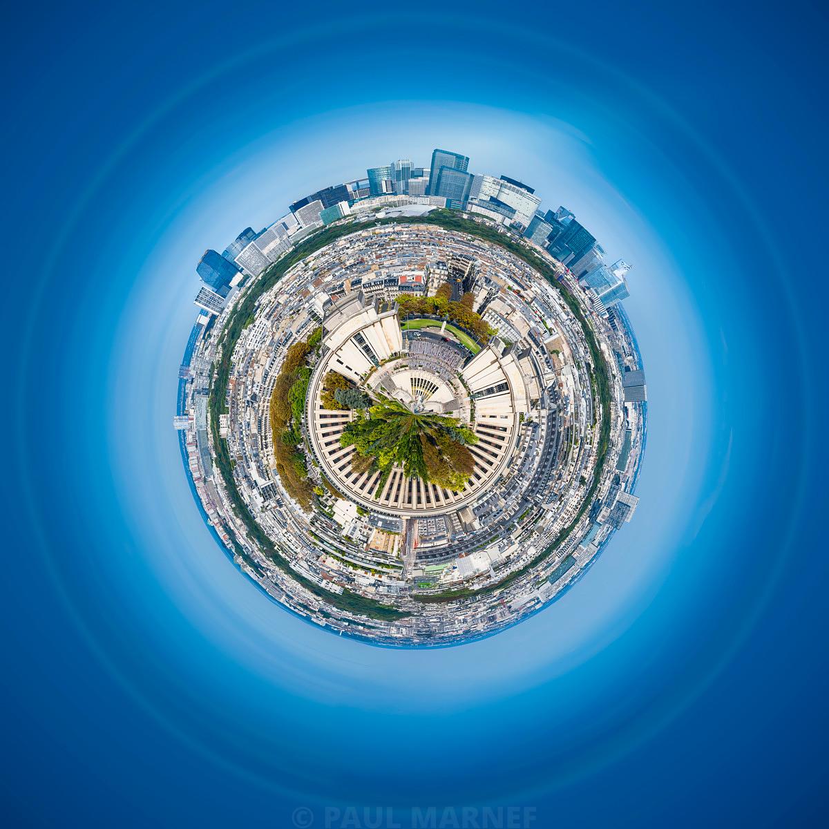 Vue aérienne en petite planète de Paris, avec l'Éiffel au centre, des toits blancs et vertueux entourés par un vaste ciel bleu.