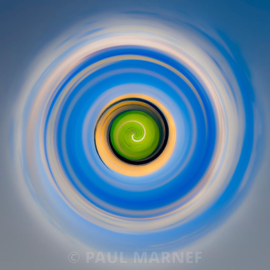Spirale de cercles concentriques allant du vert au centre vers des anneaux jaune, blanc et bleu vif sur une toile abstraite.