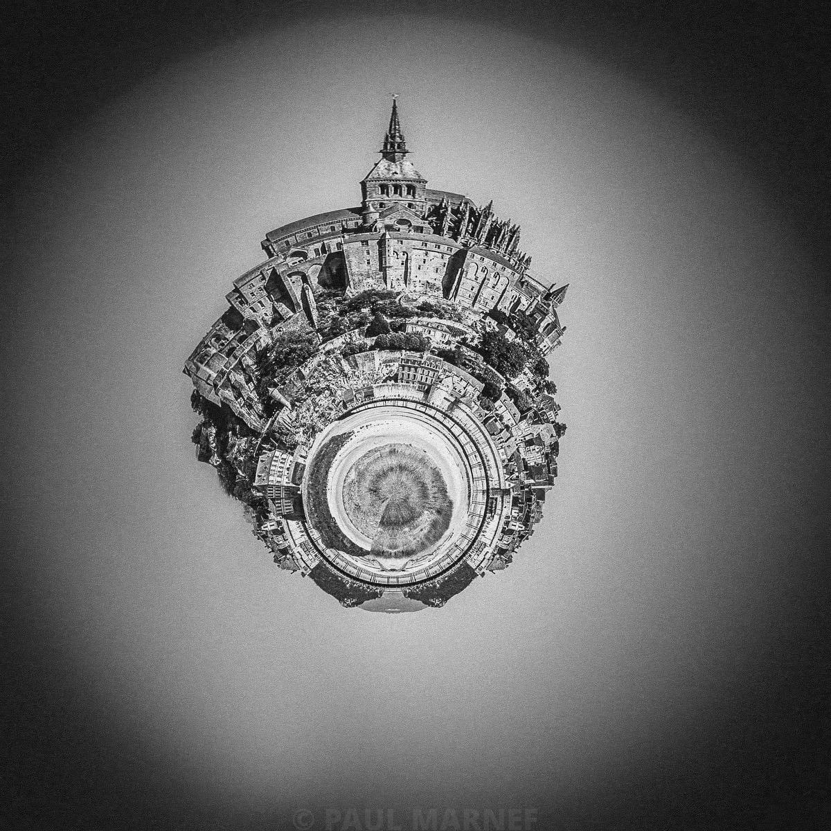Une plaine encerclée d’immeubles, formant une pupille sphérique, et une cathédrale avec flèche perchée au sommet du disque.