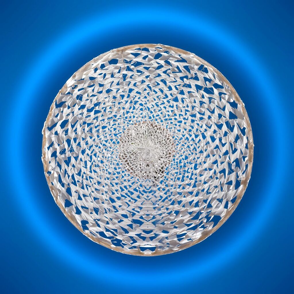 A delicate textile structure made of egg white twisted into a three-dimensional spiral, floating in a circular blue light.