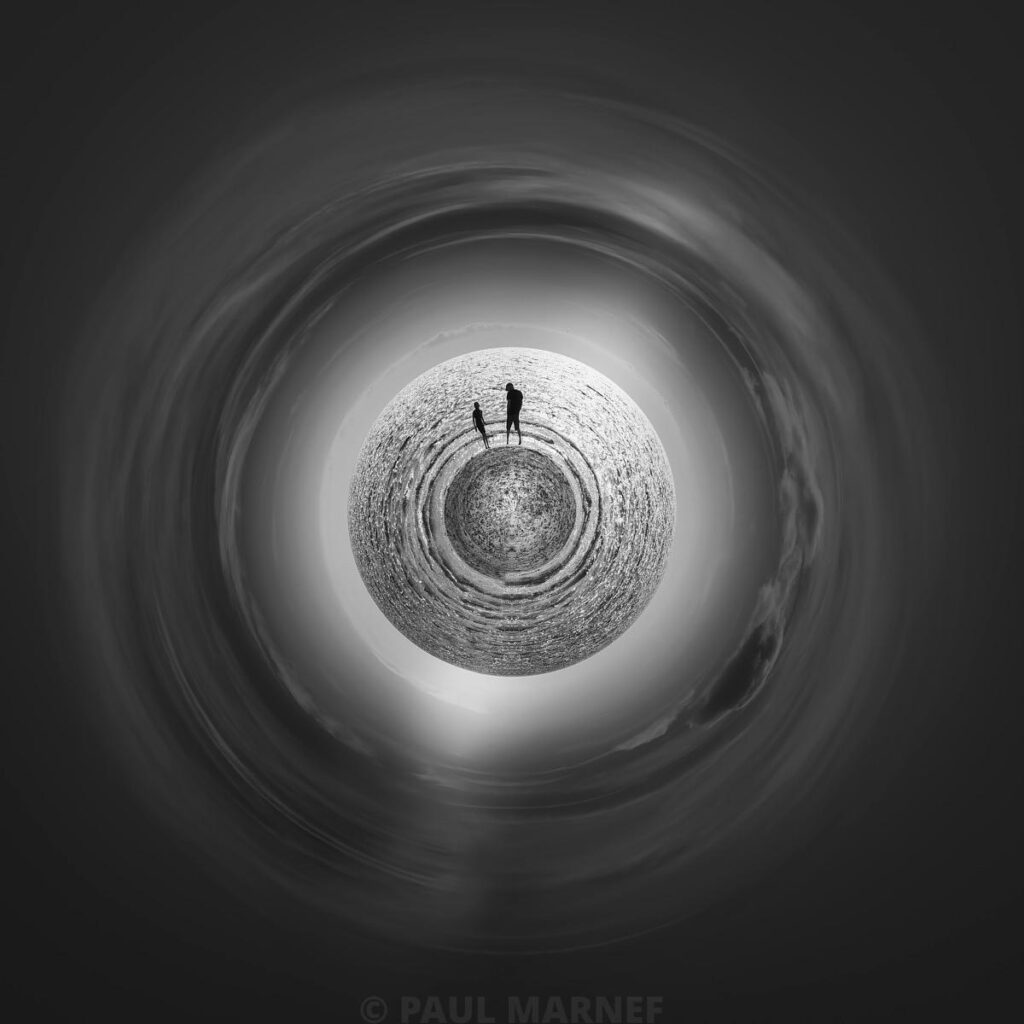 Two figures stand in the centre of a disc representing the Earth, surrounded by a circular, blurred black-and-white sky.