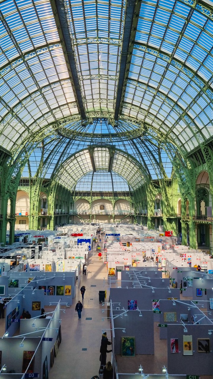Vue intérieure du Grand Palais à Paris, avec sa verrière monumentale et les stands du salon Art Capital où expose Paul Marnef.