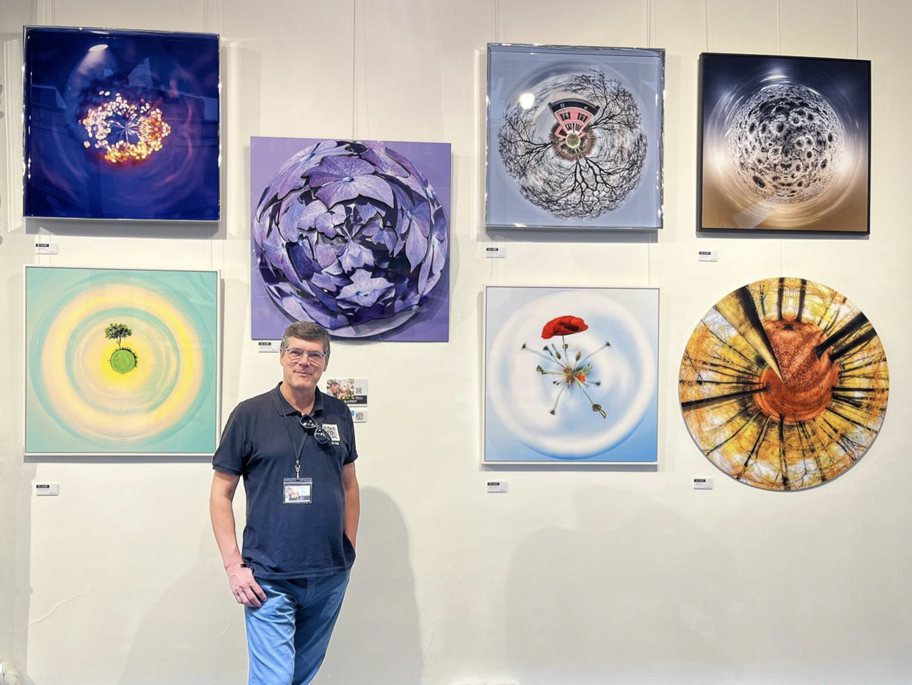 Paul Marnef devant ses œuvres photographiques Planètes Imaginaires lors d'une exposition au Bastille Design Center à Paris.