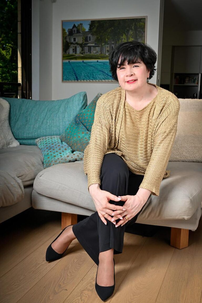 Portrait naturel d'une femme assise dans un intérieur confortable, capturé par Paul Marnef, photographe portraitiste à Bruxelles, créant une ambiance chaleureuse et détendue.