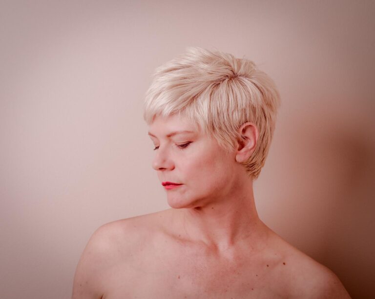 Portrait minimaliste d'une femme avec des cheveux courts blonds, capturé par Paul Marnef, photographe portraitiste à Bruxelles, exprimant sérénité et simplicité avec une lumière douce.