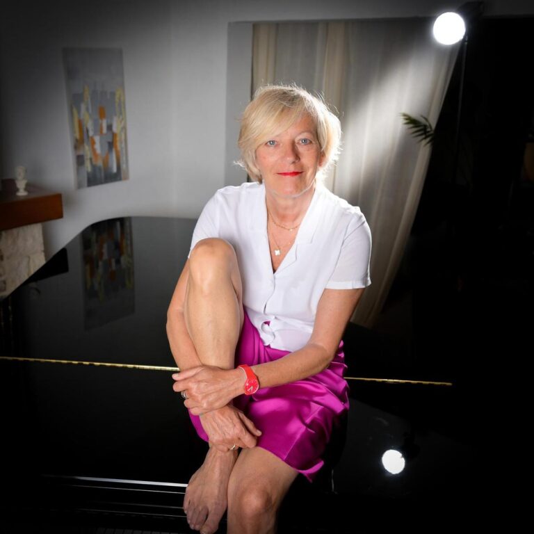 Portrait artistique d'une femme assise sur un piano à queue, capturé par Paul Marnef, photographe portraitiste à Bruxelles, montrant une ambiance lumineuse et élégante.