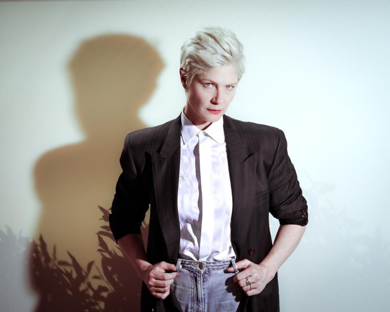 Portrait dramatique d'une femme au look sophistiqué avec un jeu d'ombres, capturé par Paul Marnef, photographe portraitiste à Bruxelles, créant une ambiance mystérieuse et élégante.