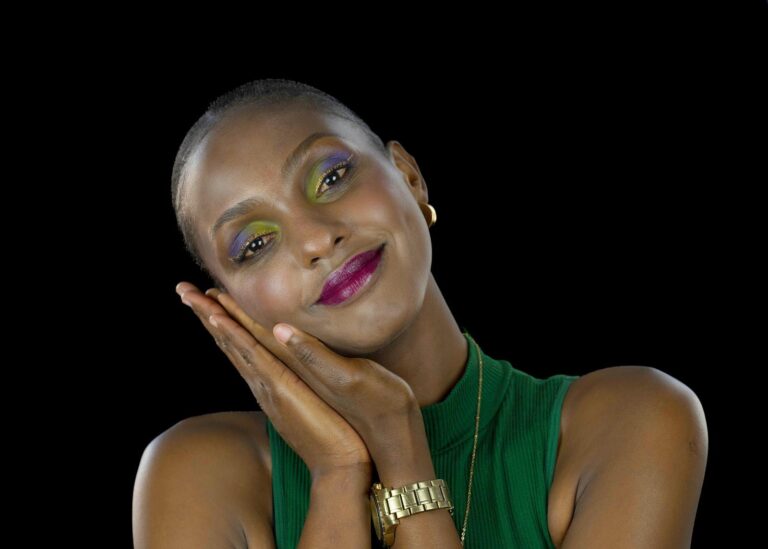 Portrait expressif d'une femme avec un maquillage vibrant, capturé par Paul Marnef, photographe portraitiste à Bruxelles. Le modèle adopte une pose délicate et élégante, créant une ambiance douce et lumineuse.